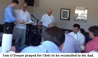 Men praying for each other.