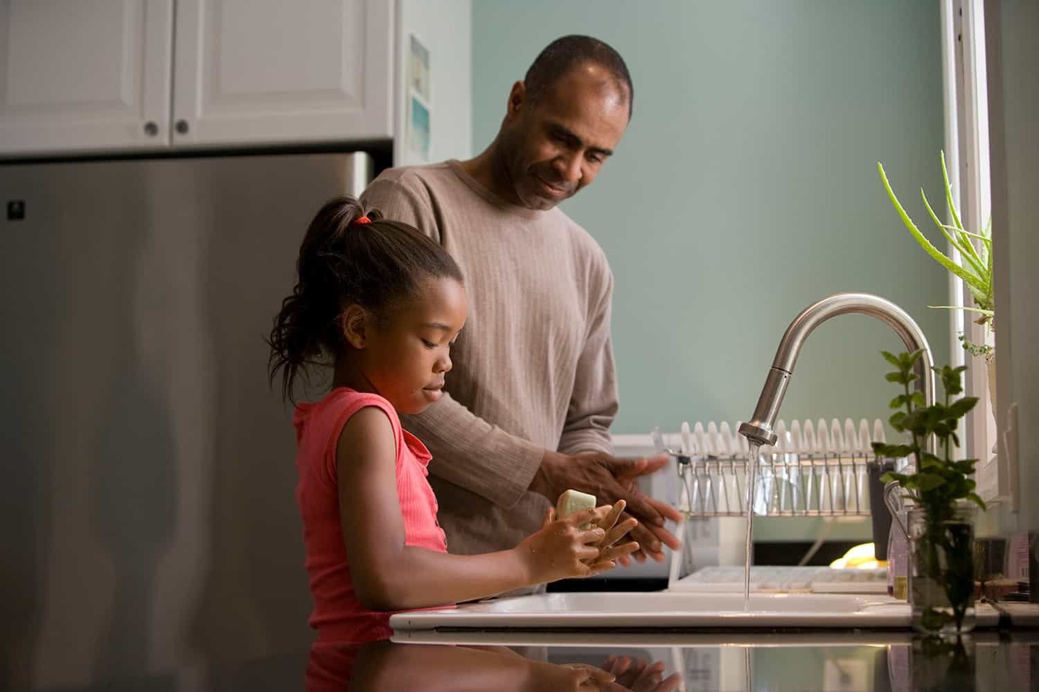 Photo of dad and daughter washing dishes on Unsplash