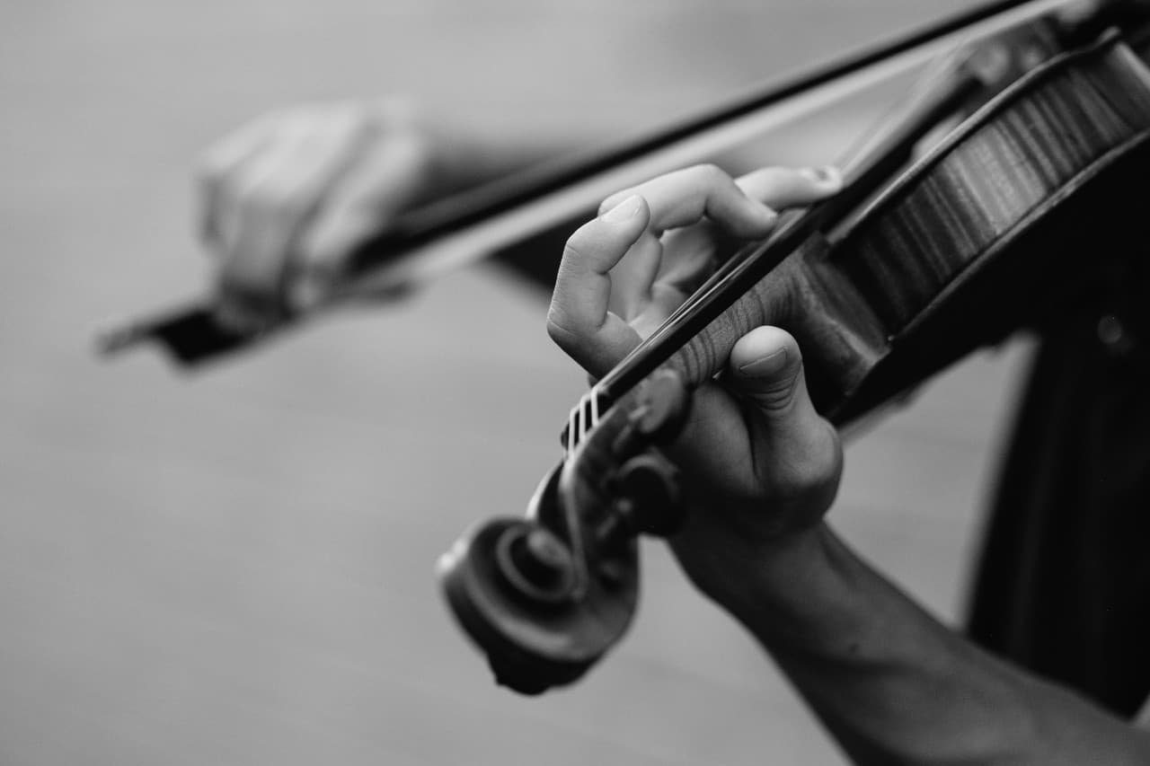 Black and white picture of a man's hands playing a fiddle