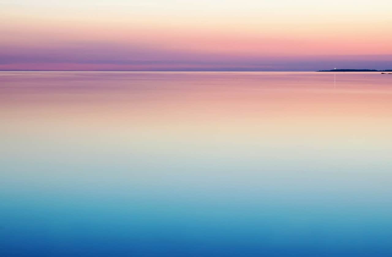 A purple and pink sunset over calm waters.