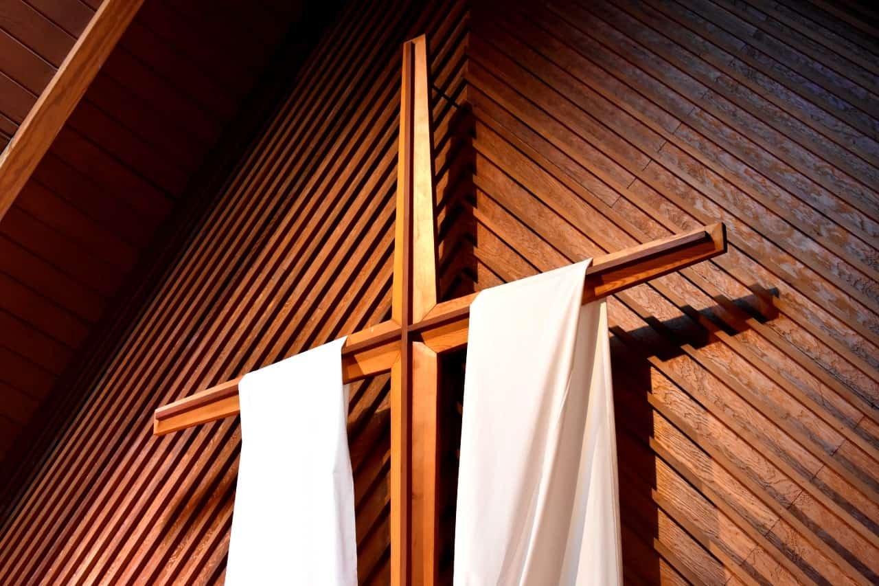 A cross with a white fabric draped over it.