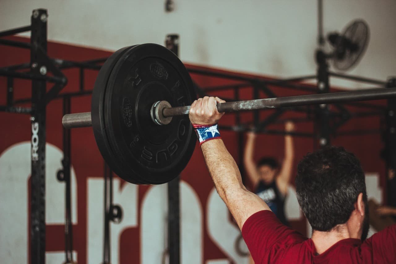 A man lifting weights above his head.